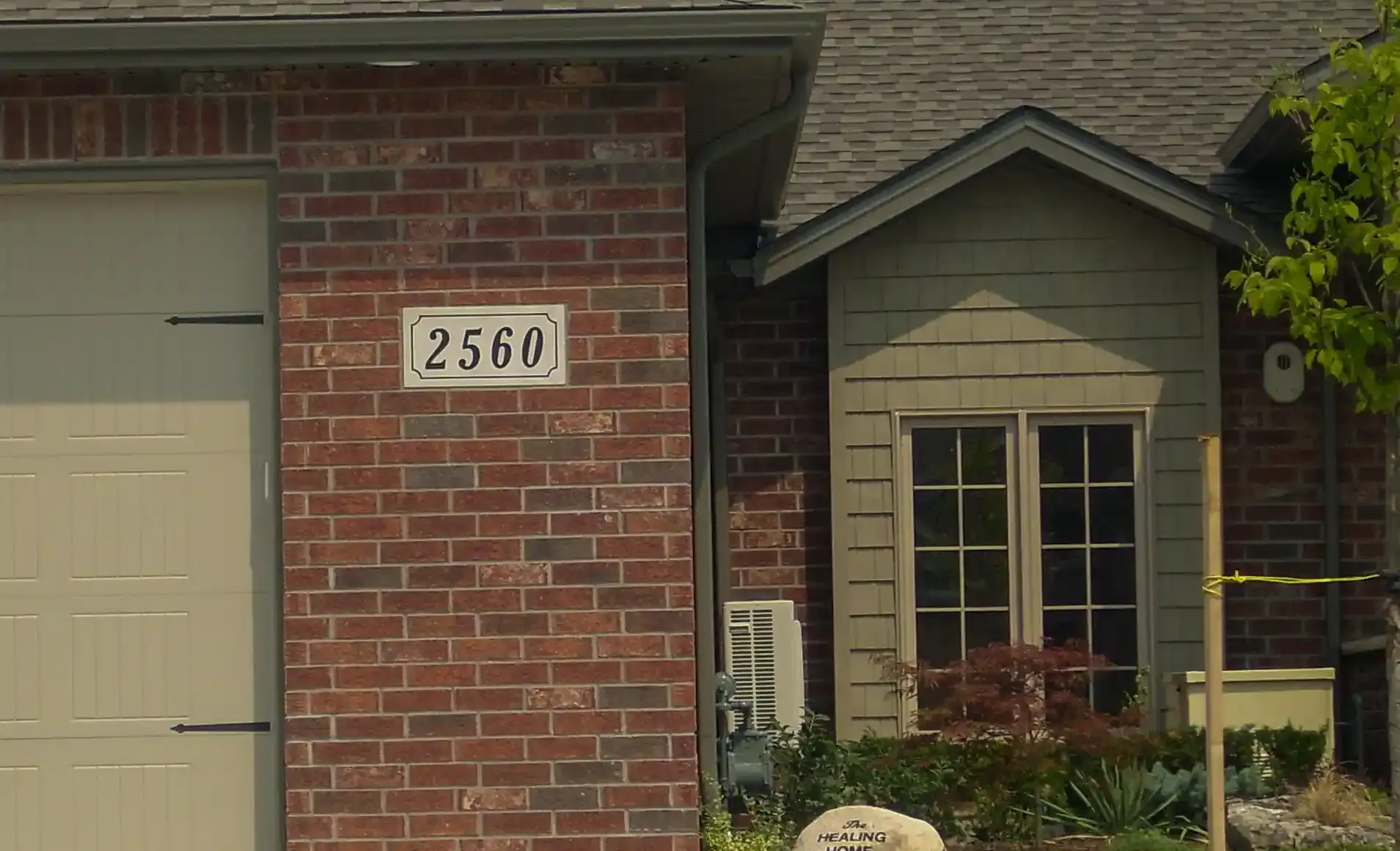 Custom engraved address stone in a landscaped garden setting